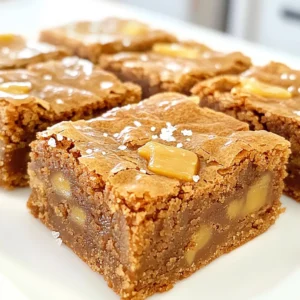 To make Brown Butter Salted Toffee Blondies, you need a few simple ingredients. Here’s what you will need: - 1 cup unsalted butter - 2 cups brown sugar, packed - 2 large eggs - 2 teaspoons vanilla extract - 2 cups all-purpose flour - 1 teaspoon baking powder - 1/2 teaspoon baking soda - 1/4 teaspoon salt - 1 cup toffee bits (or chopped toffee candy bars) - Sea salt flakes for topping These ingredients create a rich, sweet treat with a nutty flavor from the brown butter. The brown sugar adds moisture and a deep flavor. The toffee bits give a nice crunch and burst of sweetness. Using unsalted butter lets you control the saltiness. The eggs bind everything together, while the flour provides structure. Baking powder and baking soda help the blondies rise. Sea salt flakes on top add a nice contrast to the sweetness. You can adjust the amount based on your taste. Gather these ingredients before you start. Having everything ready makes baking easier and more fun! - Preheat oven to 350°F (175°C). - Grease or line a 9x13 inch baking pan. Start by warming up your oven. This helps the blondies bake evenly. Greasing or lining the pan makes it easy to take them out later. - Melt butter in a saucepan over medium heat. - Cook until golden brown and nutty aroma is released. Next, melt your butter in a medium saucepan. Keep a close eye on it. Stir often to prevent burning. After about 5-7 minutes, it should be golden brown and smell nutty. This step adds a rich flavor. - Mix brown butter with brown sugar, eggs, and vanilla. - Gradually fold in dry ingredients and toffee bits. Once the butter cools a bit, mix it with brown sugar in a large bowl. Whisk until smooth. Add the eggs one by one, stirring well. Then, stir in the vanilla extract. In another bowl, mix the flour, baking powder, baking soda, and salt. Slowly add this dry mix to the wet mix. Fold in the toffee bits gently. Make sure they spread out in the batter. - Pour batter into baking pan and sprinkle with sea salt. - Bake for 20-25 minutes and cool before serving. Now, pour your batter into the prepared pan. Smooth the top and sprinkle sea salt on top. This adds a nice contrast to the sweetness. Bake for 20-25 minutes. You know they are done when the edges set, and a toothpick comes out with a few moist crumbs. Let them cool for about 10 minutes before serving. Enjoy your warm, gooey blondies! To get brown butter just right, pay close attention. Use a medium heat to melt the butter slowly. Stir it often to prevent burning. When the butter turns golden brown, you’ll smell a nutty aroma. This step takes about 5-7 minutes. If it smells burnt, you need to start over. Mixing is key to great blondies. Overmixing can lead to tough blondies. Combine the dry ingredients until just mixed in. This keeps them soft and chewy. To check if they are done, insert a toothpick in the center. If it comes out with a few moist crumbs, they are ready. These blondies shine with a scoop of ice cream or a dollop of whipped cream. They look great on a white plate; the contrast makes them pop. You can also sprinkle extra toffee bits on top for fun. For a special touch, add a drizzle of chocolate sauce before serving. {{image_2}} You can make these blondies even tastier. Try adding nuts like walnuts or pecans. They add a nice crunch and flavor. You can also mix in chocolate chips. Dark chocolate pairs well with the sweet toffee. Use milk chocolate for a sweeter bite. You can switch up your toffee bits too. Try using different types of candy bars. Snickers or Heath bars can add a fun twist. Experimenting with flavors keeps your blondies exciting. Want to make these blondies gluten-free? Use a gluten-free flour blend instead of all-purpose flour. The texture may change a bit, but they will still taste great. For a vegan version, replace the eggs with flax eggs. Mix one tablespoon of flaxseed meal with three tablespoons of water for each egg. Use a plant-based butter instead of regular butter. This way, everyone can enjoy the treat. Add some spice for a seasonal touch. Ground cinnamon or nutmeg can warm up the flavors. These spices work well in the fall or winter. You can also use seasonal toppings. Drizzle caramel sauce over the top for a sweet finish. Fresh fruits like berries or sliced peaches can add freshness in summer. These little changes keep your blondies fun and interesting all year long. Cooling your blondies before storage is key. This step helps them set properly. If you skip it, you may end up with soggy blondies. To cool them, let the blondies sit in the pan for about 10 minutes. Then, move them to a wire rack. This allows air to flow around them, keeping a nice texture. For storage, using airtight containers is best. They keep your blondies fresh and prevent them from drying out. You can also wrap them tightly in plastic wrap. If you live in a warm area, store them in the fridge. However, at room temperature works fine too. Just keep them away from sunlight and heat. You can keep your blondies fresh for about 5 days at room temperature. In the fridge, they last up to 10 days. Look for signs of spoilage like a hard texture or dry edges. If they smell off, it’s best to toss them out. Always trust your senses to check freshness. How do you make brown butter? To make brown butter, start by melting unsalted butter in a saucepan over medium heat. Stir it often. Watch for it to turn a golden brown. You will smell a nutty aroma when it's ready. This process takes about 5 to 7 minutes. Be careful not to let it burn, as this will change the flavor. Can I use margarine instead of butter? You can use margarine, but it won't give the same rich flavor. Butter adds a creamy taste that margarine lacks. Brown butter also brings out a deep, nutty flavor that margarine cannot match. For the best results, stick to butter. What if I don’t have toffee bits? If you don’t have toffee bits, you can use chopped toffee candy bars. Another option is to use chocolate chips or nuts. These will change the taste but still create a tasty treat. Just remember to adjust the amount to fit your preference. Can I use different pan sizes? Yes, you can use different pan sizes, but it may change the baking time. A smaller pan makes thicker blondies, while a larger pan makes thinner ones. Keep an eye on them as they bake. Check for doneness a few minutes early if you change the pan size. What should I do if my blondies are too gooey? If your blondies are too gooey, they might need more baking time. Make sure to check them with a toothpick. If the toothpick comes out with wet batter, put them back in the oven. Bake for another 5 minutes and check again. You want a few moist crumbs, not wet batter. Can these blondies be frozen? Yes, you can freeze these blondies. Allow them to cool completely first. Cut them into squares and wrap each piece in plastic wrap. Place them in a freezer-safe bag. They will stay fresh for up to three months. What drinks pair well with blondies? Blondies pair well with milk, coffee, or tea. A glass of cold milk enhances the sweet flavor. For coffee lovers, a cup of strong brew complements the taste nicely. If you prefer tea, try a light herbal tea for a balanced pairing. We explored the tasty world of Brown Butter Salted Toffee Blondies. We listed the key ingredients, explained the baking steps, and shared helpful tips. Variations let you play with flavors and textures, while storage info keeps your treats fresh. Enjoy baking these delicious blondies and impress your friends. You can mix in nuts, spices, or even make them gluten-free! Remember, the right cooling and storage methods make a big difference. Now, get ready to blend flavors and create sweet memories. Happy baking!